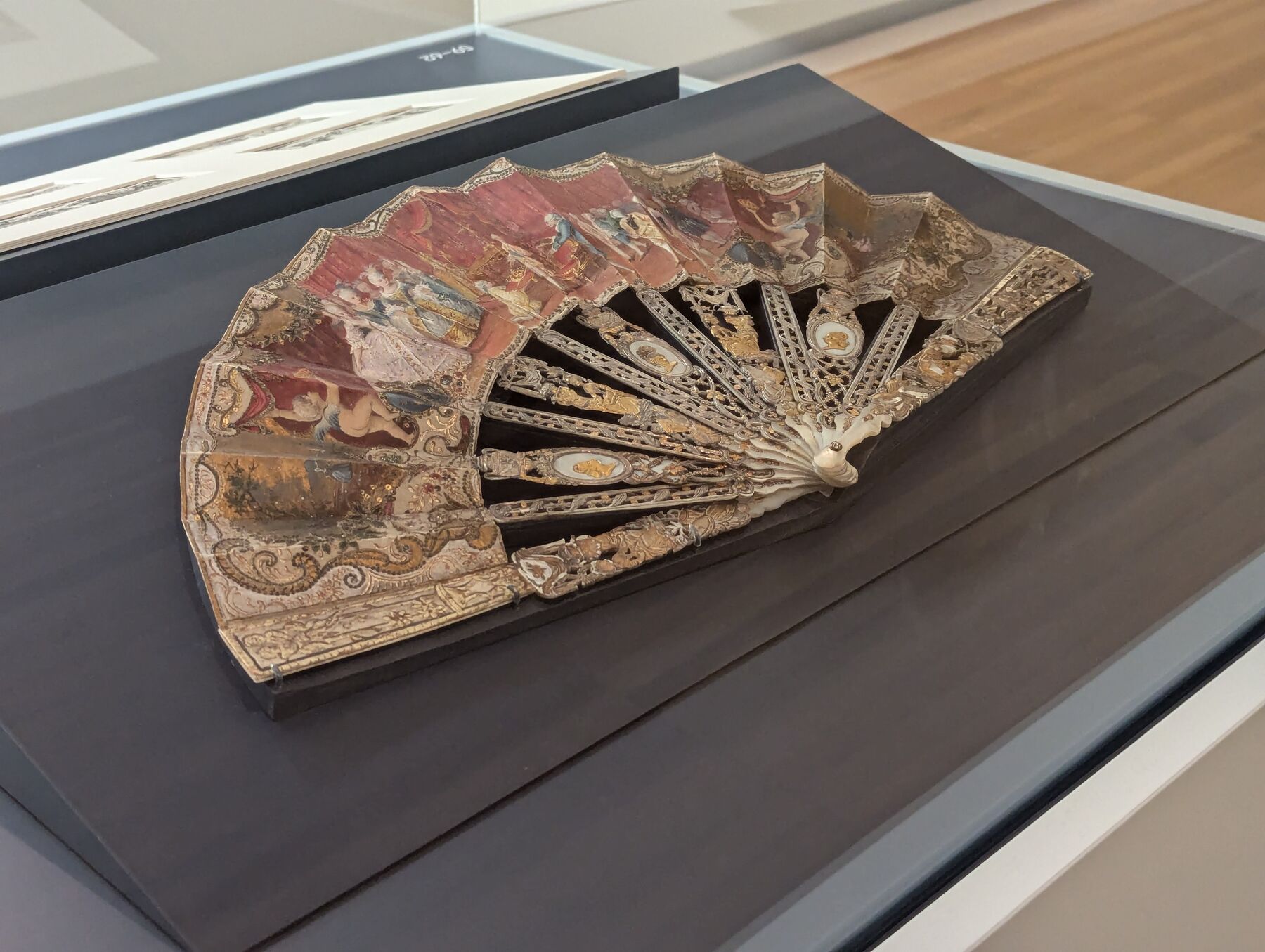 The antique fan displayed on its custom mount in the Carnegie Museum exhibition